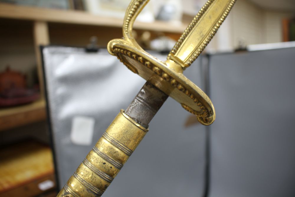 A cut steel dress sword by Ede & Ravenscroft of London and two brass hilted dress swords